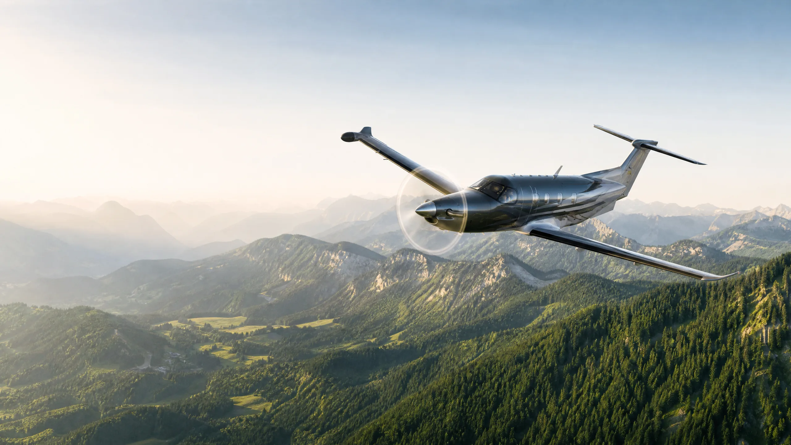 PC-12 flying above an alpine forest